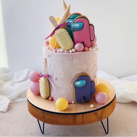 38 Cute Among Us Cake Ideas : Light Pink Cake Topped with Cake Pops