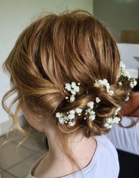 28 Enchanting Flower Girl Hairstyles : Messy Low Bun with Baby's Breath