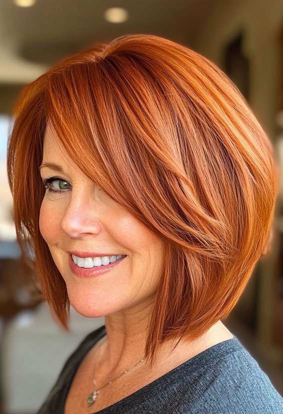 40 Layered Bob Hairstyles for Women Over 50 : Fiery Auburn Bob with Side-Swept Layers