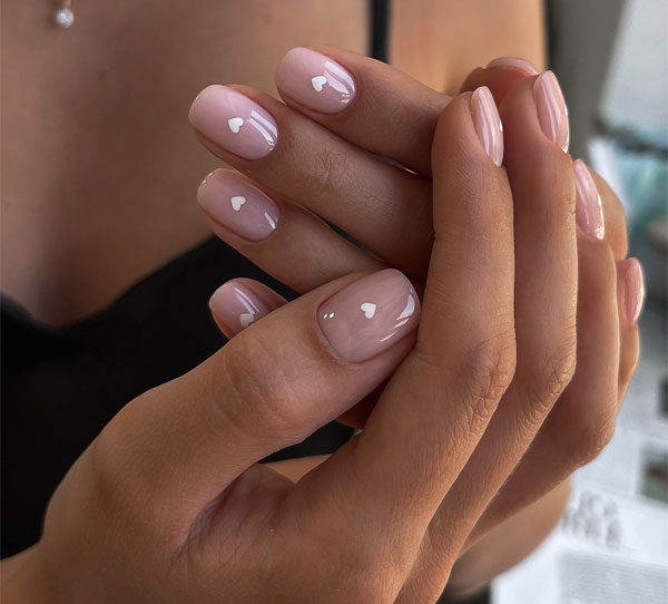 20 Minimalist Valentine’s Day Nail Designs : Glossy Nude Nails with White Heart Details