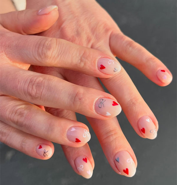 20 Minimalist Valentine’s Day Nail Designs : Nude Nails with Delicate Hearts and Bow Details