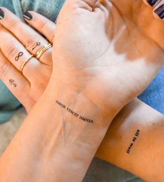 Amor fati lettering tattoo on the inner forearm