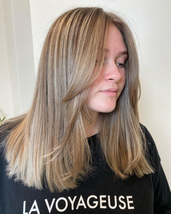 Blonde straight mid-length haircut with blunt cut and curtain bangs