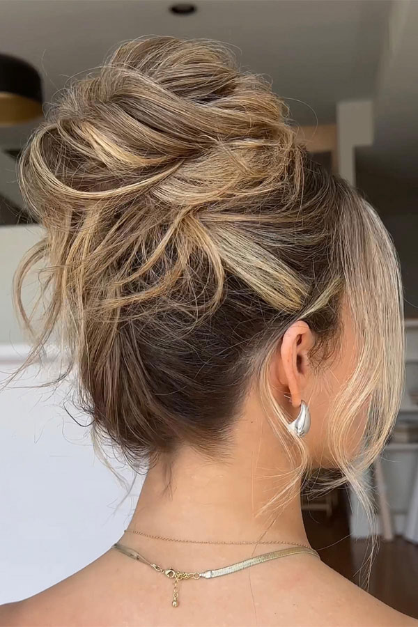 Messy Blonde Piled Updo with Face-Framing Strands, 90s inspired updo, Pamera Anderson inspired updo, piled updos, trending piled updo hairstyle, trendsetting updo hairstyle