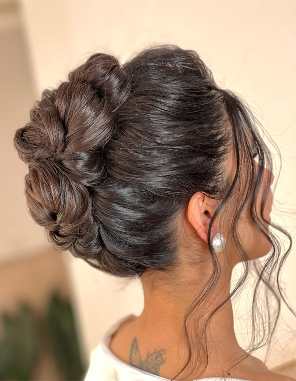 Sleek Knotted Updo with Loose Tendrils, 90s inspired updo, Pamera Anderson inspired updo, piled updos, trending piled updo hairstyle, trendsetting updo hairstyle