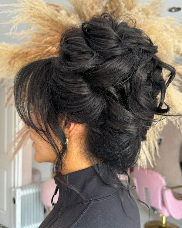 Voluminous Black Updo with Wispy Bangs, 90s inspired updo, Pamera Anderson inspired updo, piled updos, trending piled updo hairstyle, trendsetting updo hairstyle