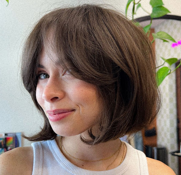 27 French Hairstyles for a Chic Makeover: Soft Layered Bob with Curtain Bangs